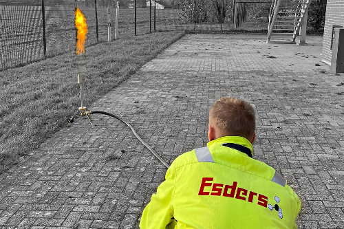 Mobile gas flare in operation when draining. A skilled worker observes the process.